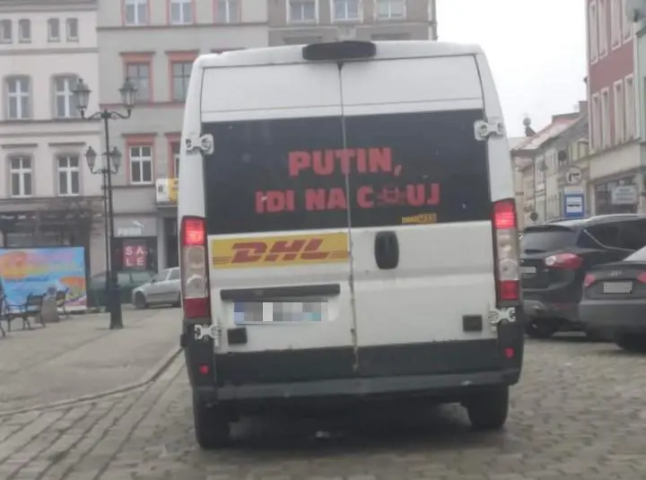 A DHL delivery van with Putin go fuck yourself in russian written on it's back window